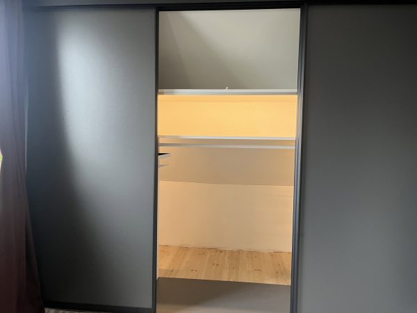 Måttanpassad garderob under snedtak med skjutdörrar och inredning från Garderobsfabriken