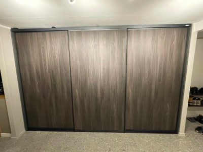 Måttanpassade skjutdörrar med svart ram och mörk ek trä från Garderobsfabriken